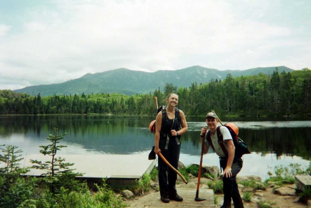 Two crewmembers pose for a photo at Lonesome Lake